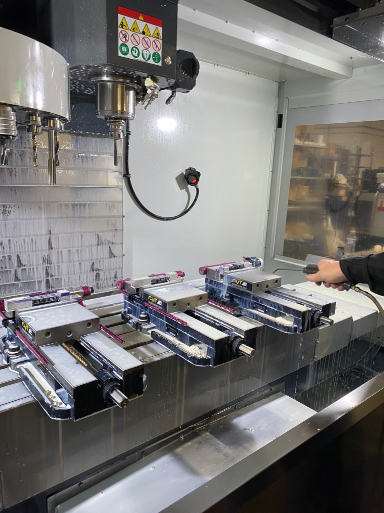 The inside of a CNC machine as parts are being removed.