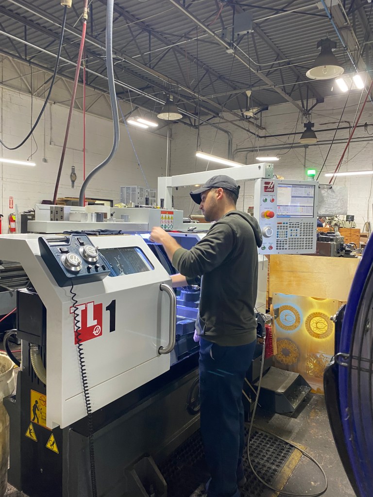 A man setting up a part in a CNC machine.